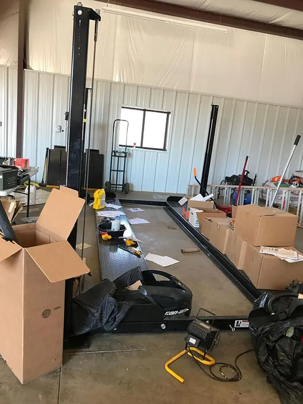 The new 4-post lift Faces of Valor USA purchased for Lance Corporal Sean Adams, now in his shop with boxes of new tools.