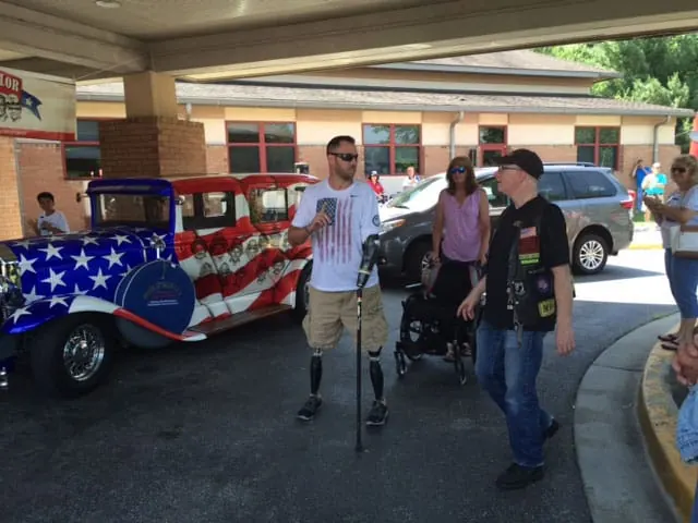 Adam in front of the Faces of Valor USA car